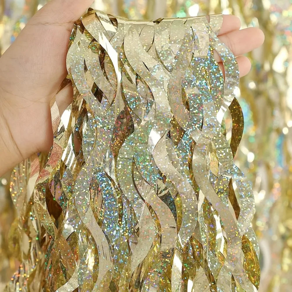 Close-up of gold laser wavy foil fringe curtain decor being held by a hand.
