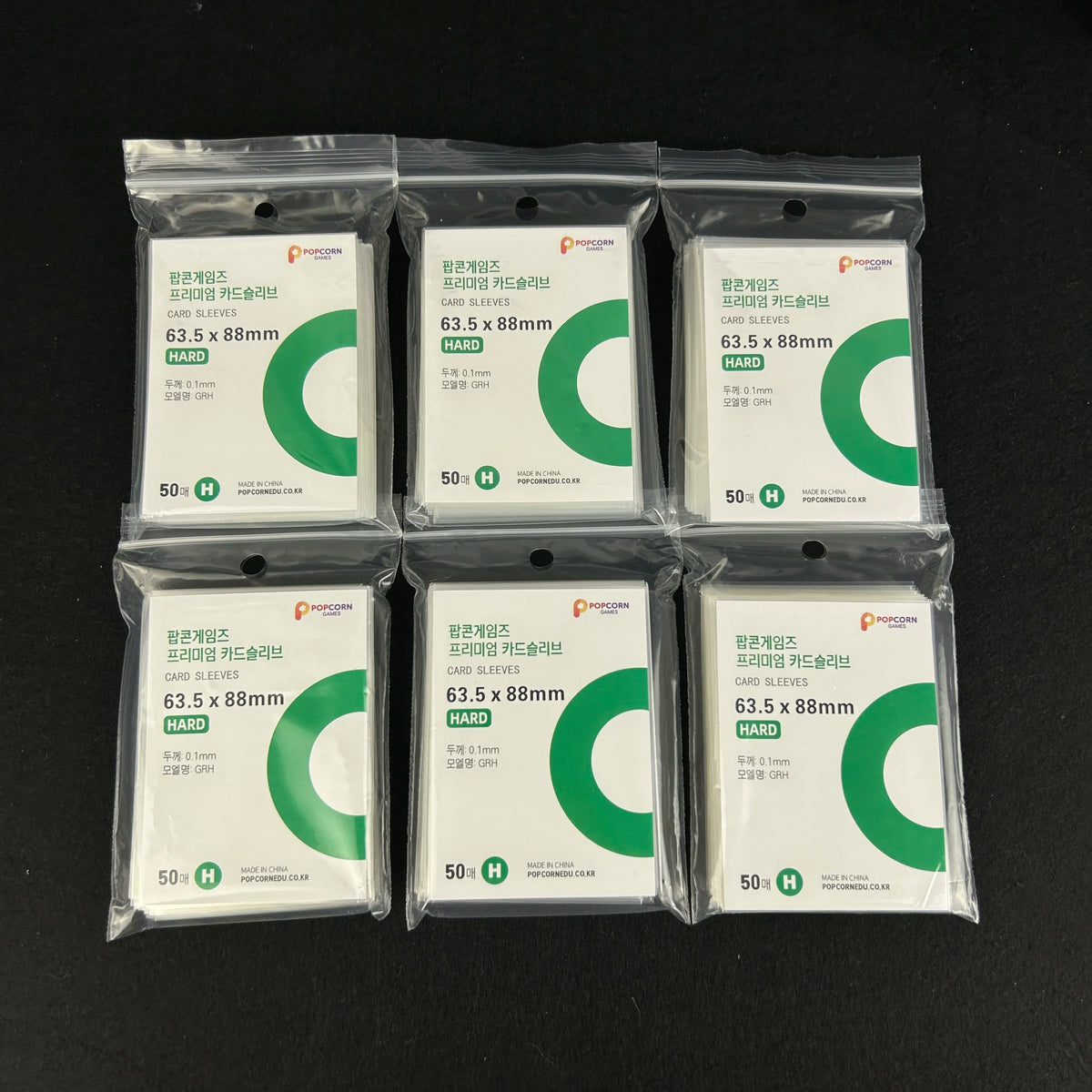 A collection of 15 sealed packages of clear protective card sleeves for cards, labeled as 50 pack.