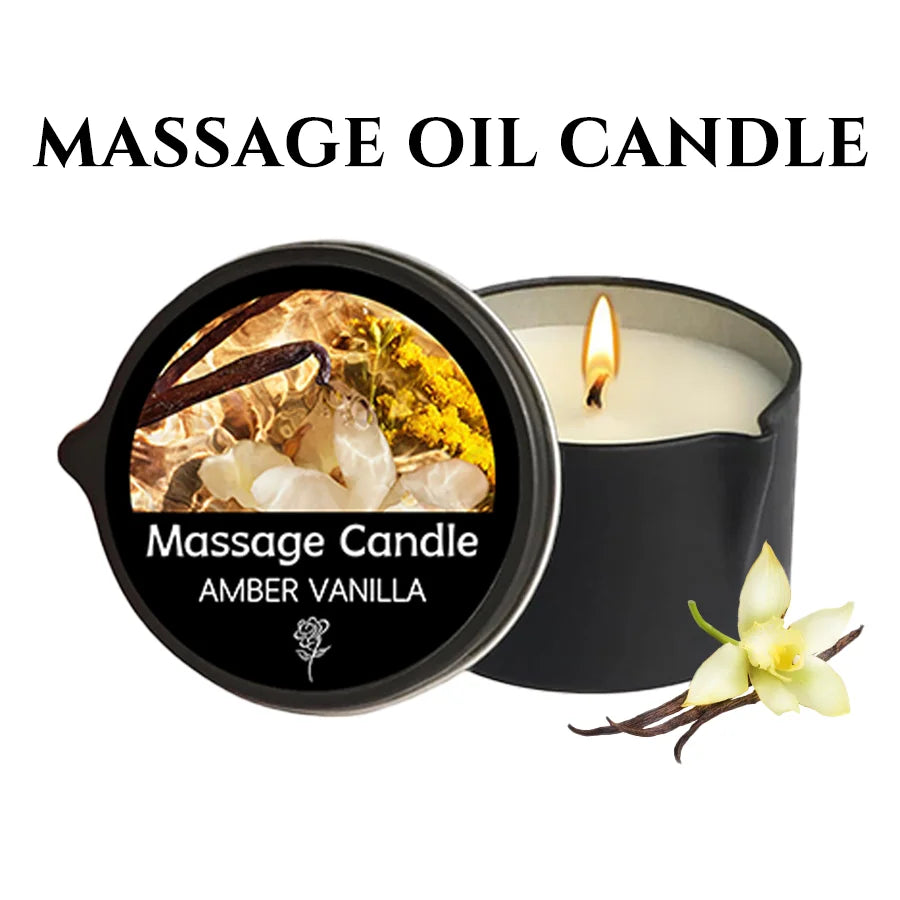 A black jar of Amber Vanilla massage candle with a lit wick and a white orchid flower nearby.