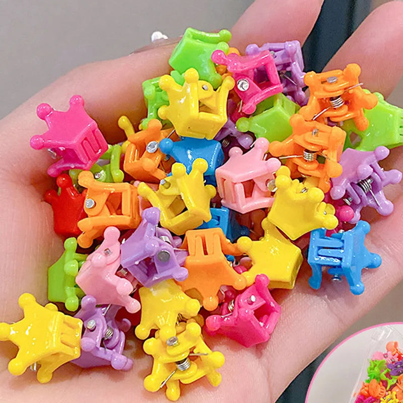 A collection of colorful flower and star hair claw clips for kids held in a hand.