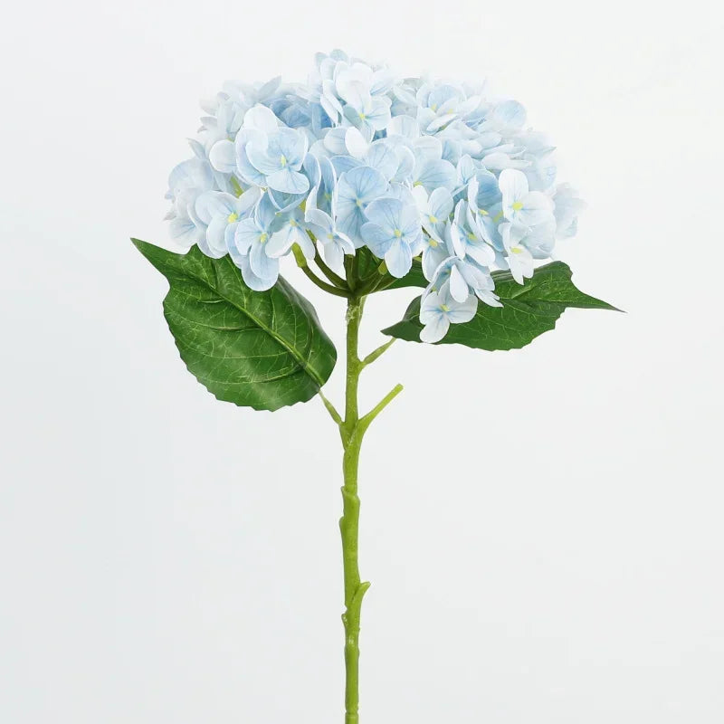 A sprig of artificial light blue hydrangea flowers with green leaves on a stem.