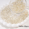 A clear glass spacer bead is shown in a small glass bowl with many beads scattered around it.