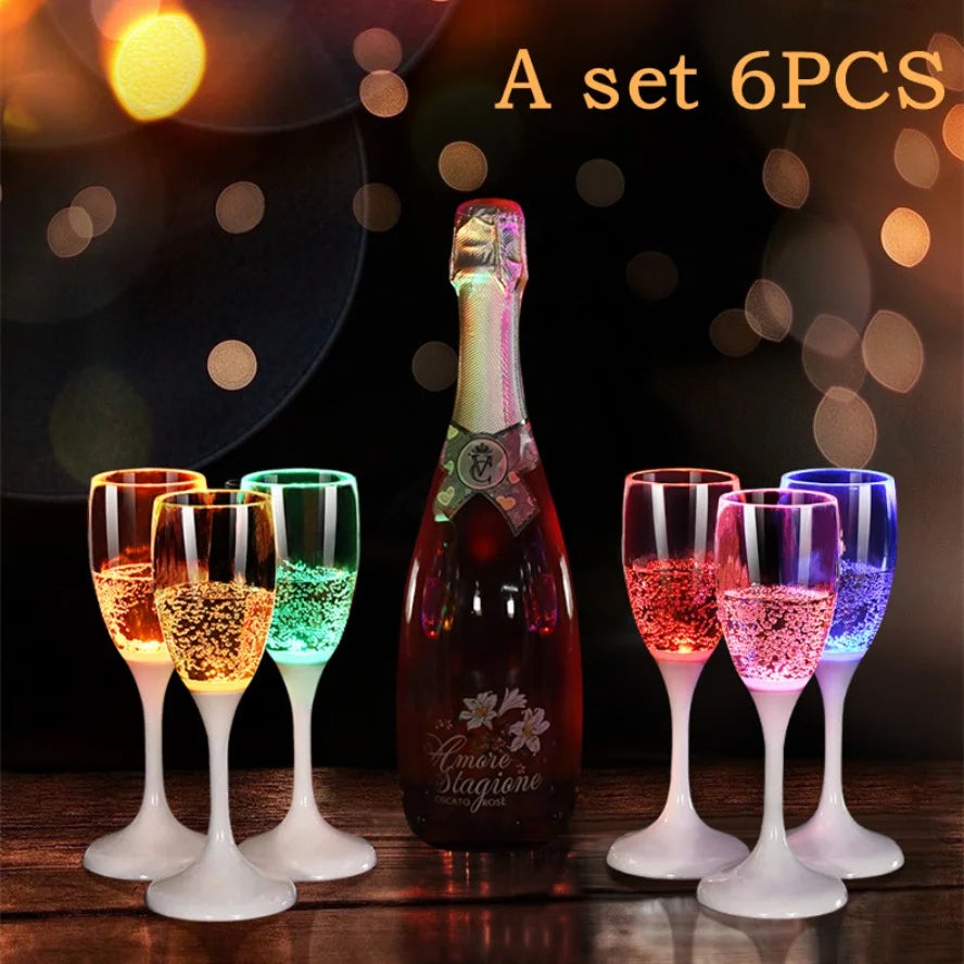 Un set de six verres à boire LED multicolores clignotants sur une surface en bois.
