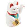 A white ceramic figurine of a cat wearing a red collar and green vest, sitting in a pose.