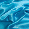 Blue satin fabric draped and folded for sewing or DIY projects