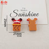 Two resin cabochons shaped like a walking figure on sunshine, one red and orange, the other orange.