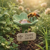 A bee is visiting a green flower cup in a garden setting.