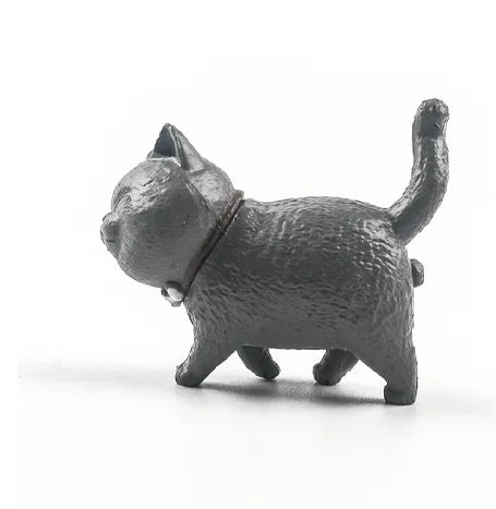 A dark gray 3D cartoon cat figurine used as a refrigerator magnet.