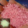 A handful of pink luminous pebbles used for garden and aquarium decor.