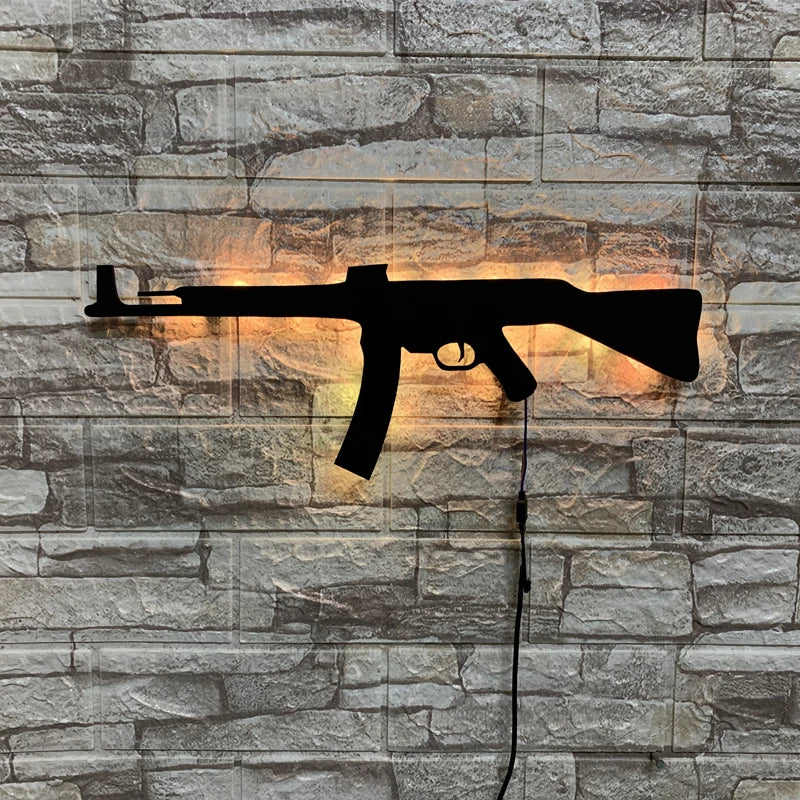 A black gun-shaped LED light fixture mounted on a gray stone wall.
