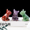 Three natural crystal dog statues in red, purple, and green sitting on a white box.