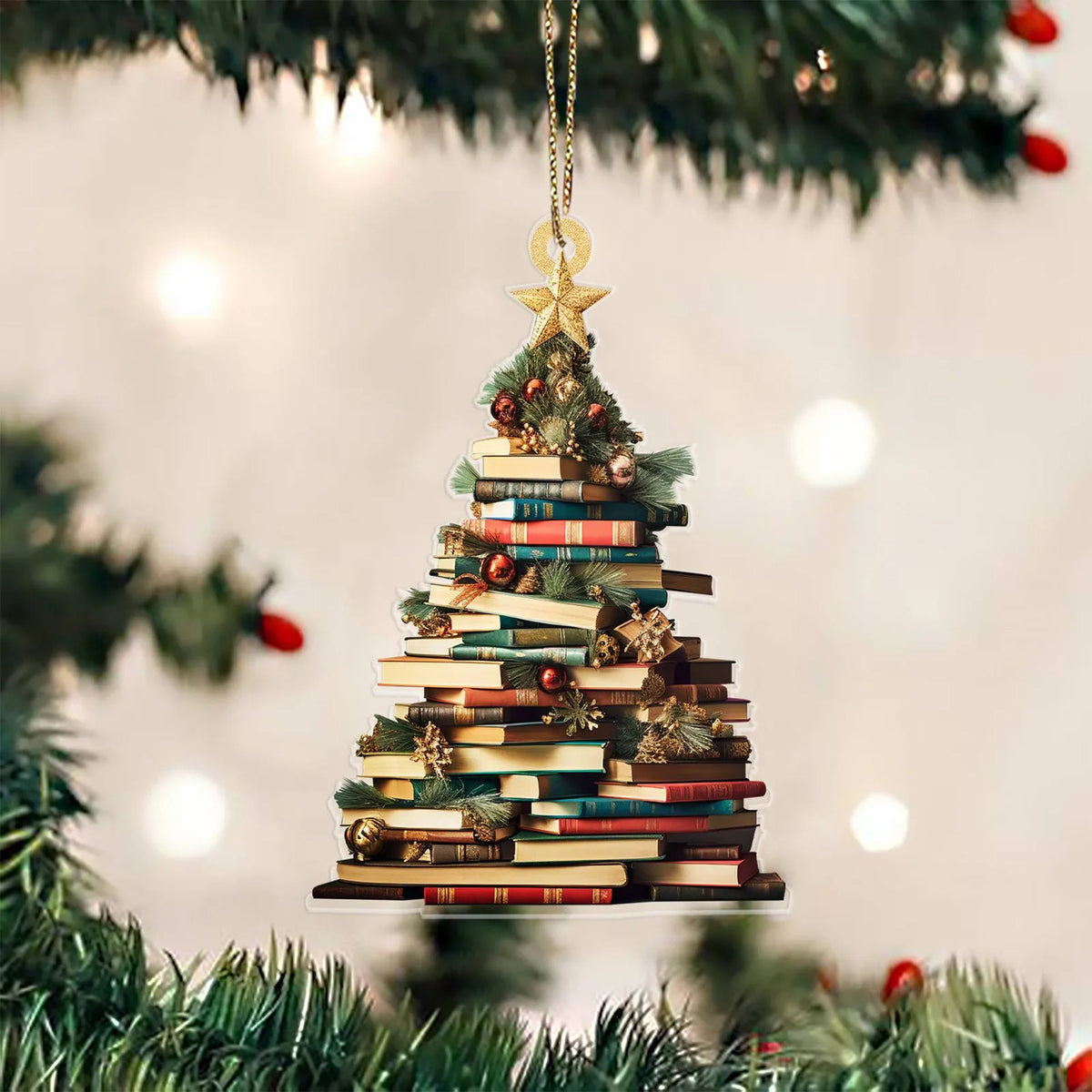 Un sapin de Noël décoré de livres empilés suspendus à un ornement doré sur une branche de pin verte.