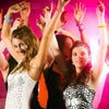 A group of women raising their hands in celebration with LED flash bracelets and party wristbands.