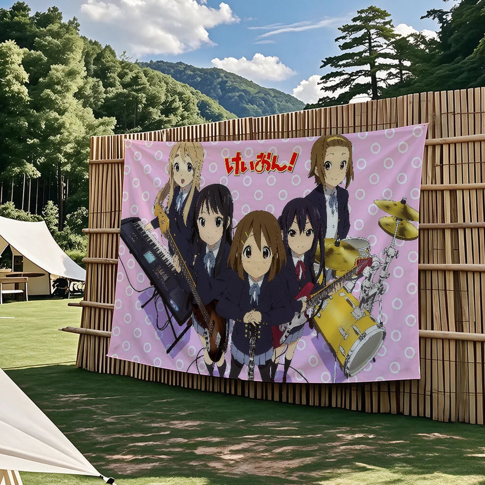 A large flag tapestry featuring the K-On! anime characters performing music against a bamboo backdrop.