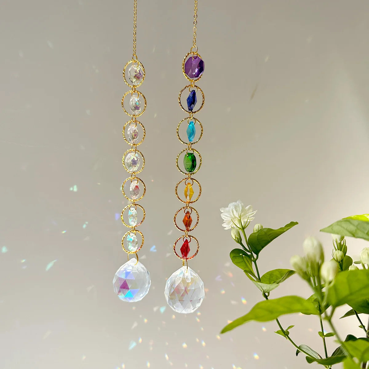 A pair of long, delicate earrings featuring a string of clear crystals and colorful gemstone drops.