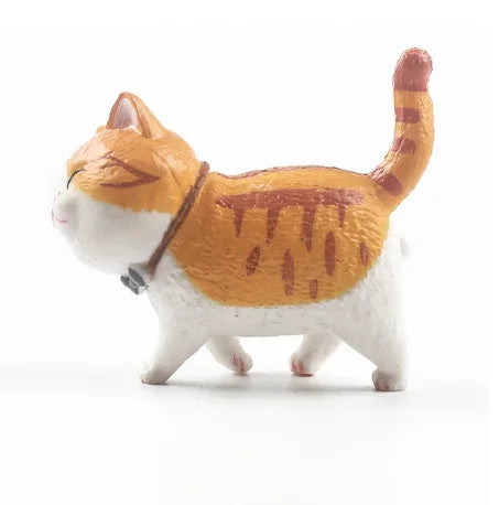 A small, white and orange 3D cartoon cat figurine with an orange body and white paws.