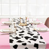 Pink cow print western tablecloth set for parties with candles and glassware