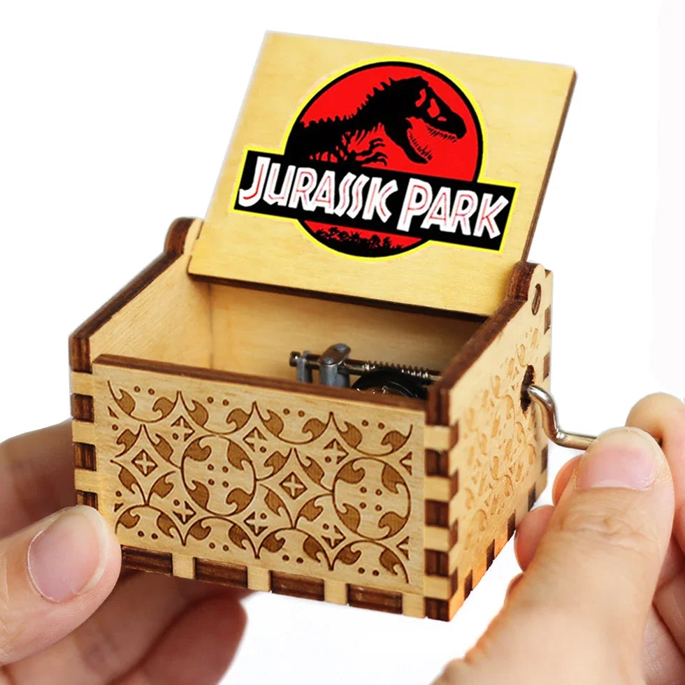 A carved wooden music box with a lid featuring the Jurassic Park logo on a light wood background.