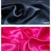 Two swatches of satin fabric, one black and one pink, showing the drape and sheen.