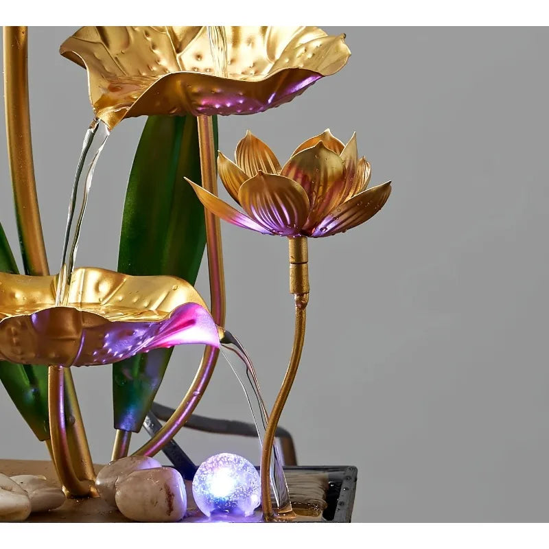 A golden lotus pond tabletop water fountain with purple LED lighting pouring water into petals.
