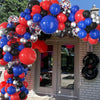 A colorful archway made of red, blue, and silver latex balloons decorated for a party.