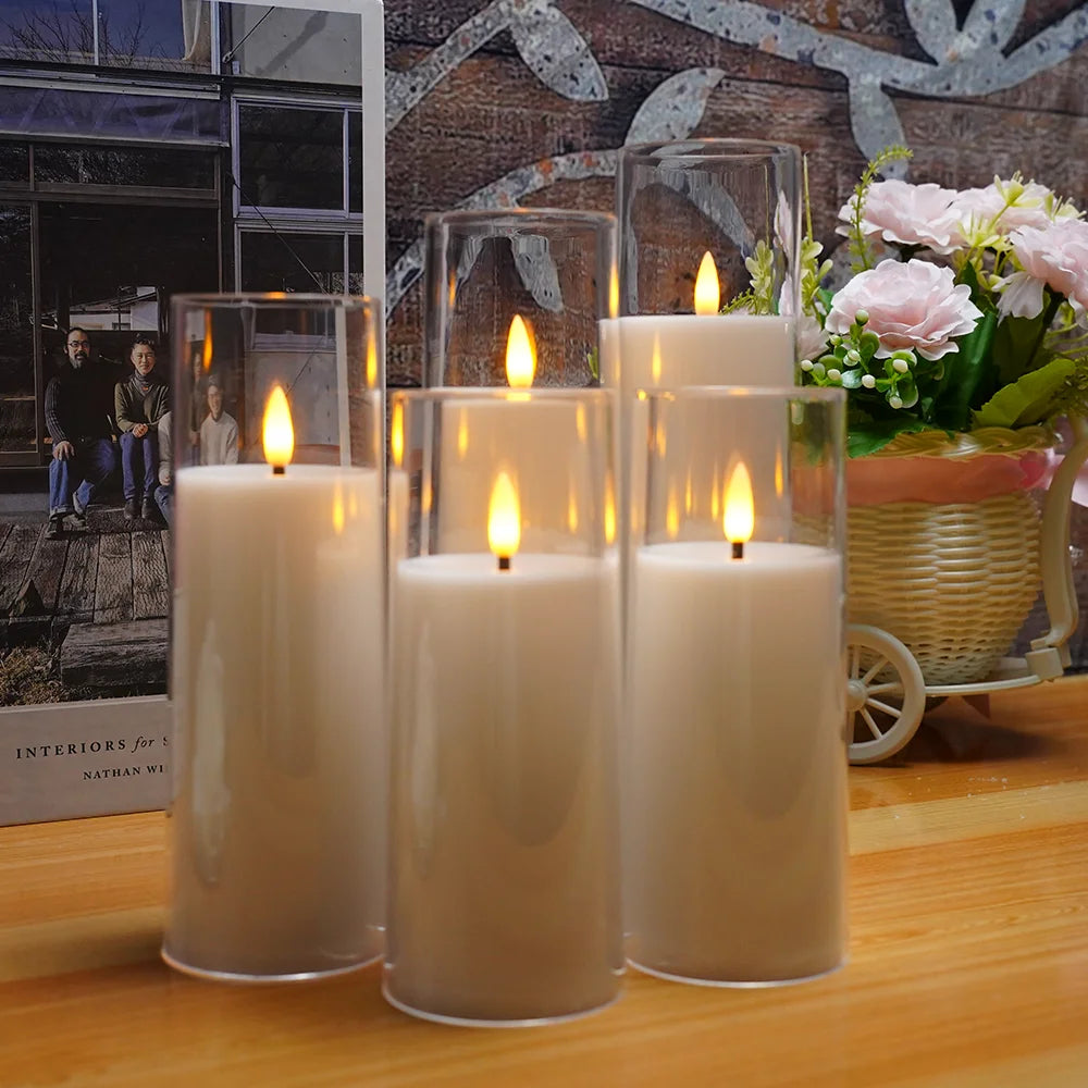 A set of five classic candles are displayed on a wooden surface with lit flames and a floral background.