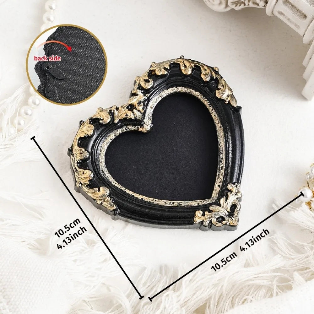 A black vintage baroque resin heart-shaped photo frame with gold accents shown on a white surface.