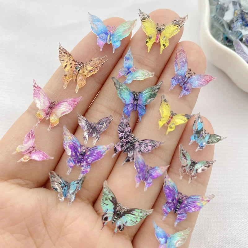 A hand holds a collection of 30 colorful resin butterfly embellishments in various shades of blue, purple, and yellow.