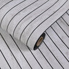 Roll of self-adhesive 3D wood grain wall panels showing dark and light stripes.