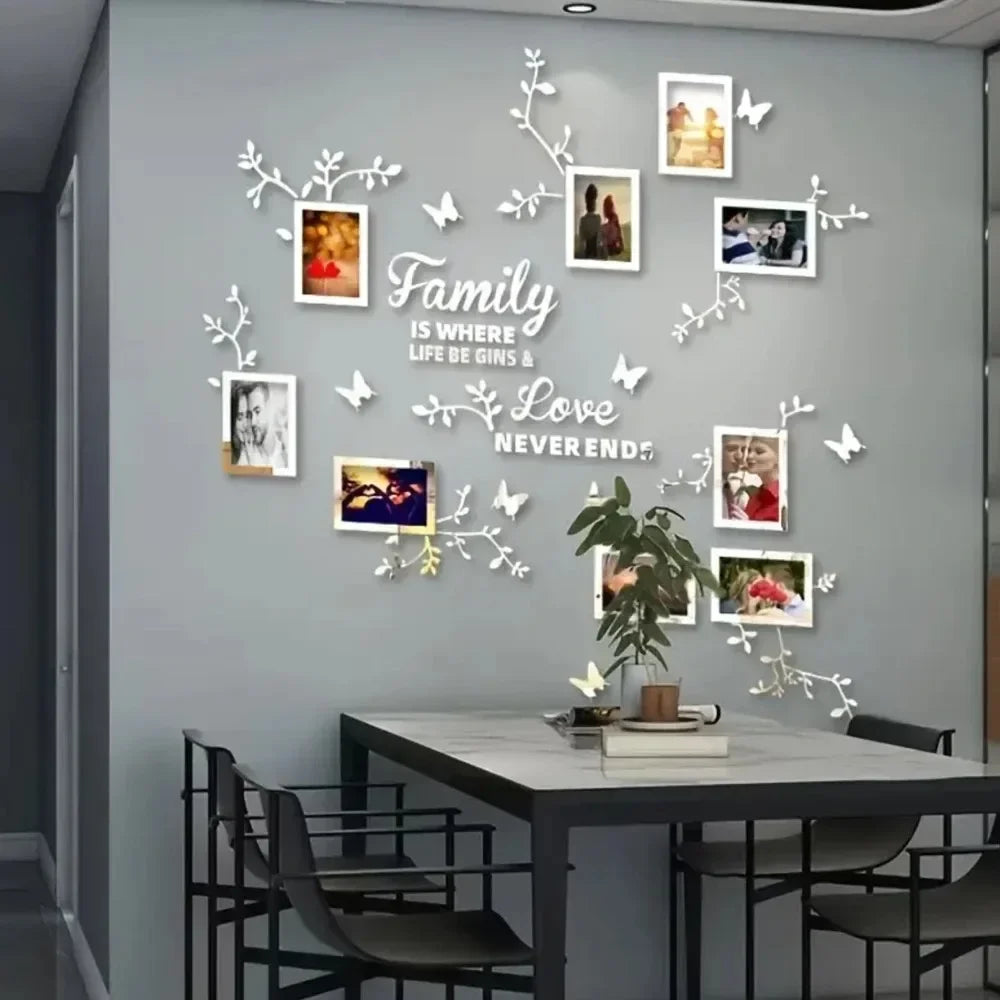 A gray wall decorated with white acrylic mirror tree decals and framed photos, featuring the text Family is where life be gin