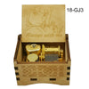 A wooden music box with a lid featuring an anime character and a golden mechanism inside.