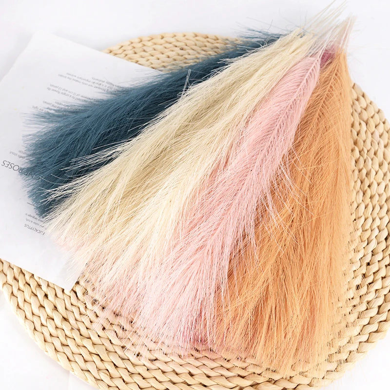 A bundle of 15 artificial reed bouquet pieces in shades of blue, cream, and peach resting on a woven mat.