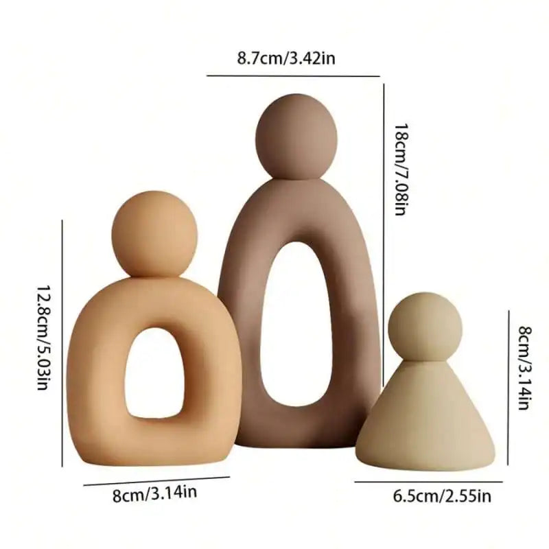 A set of three modern resin family statues in a neutral beige color.