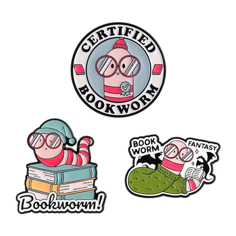 A set of enamel pins featuring a certified bookworm design and a cartoon cat with glasses.