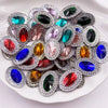 A collection of flatback rhinestone gemstones in various colors and cuts arranged on a white plate.