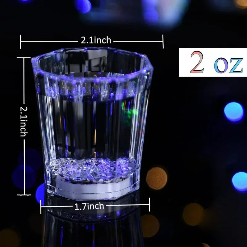 A clear shot glass filled with blue LED lights, measuring 2 oz, shown against a dark background.