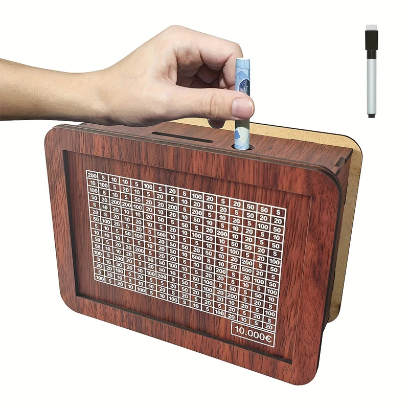 A hand places a banknote into a wooden savings box that features a progress tracker grid.
