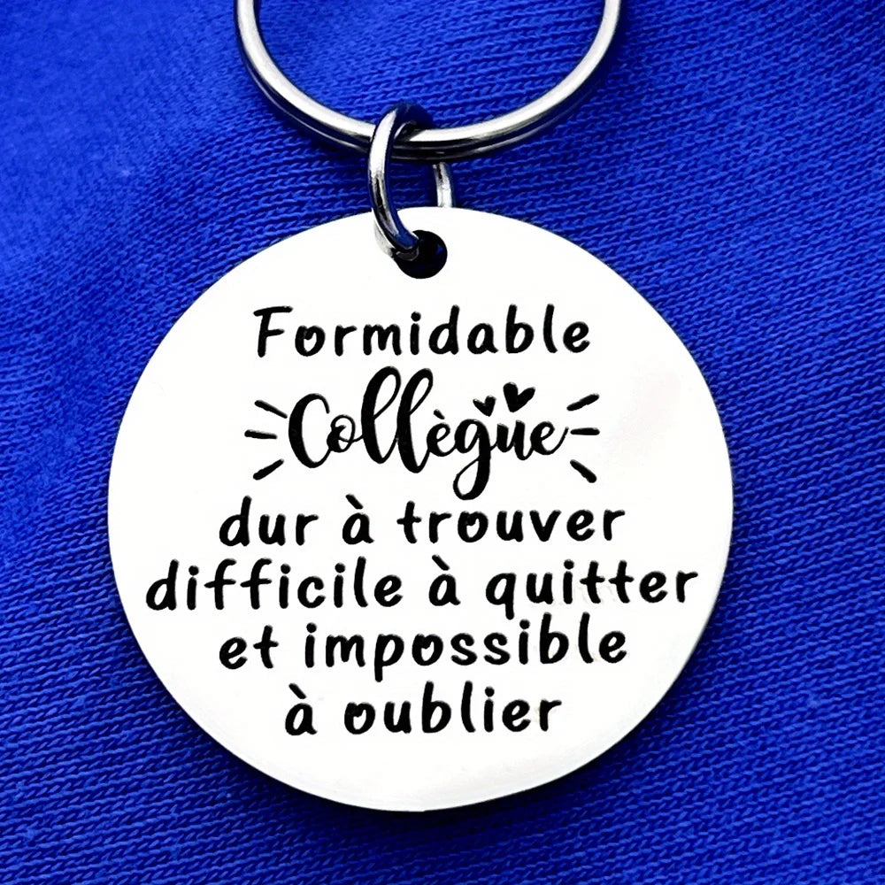 Silver keychain with a circular engraved tag featuring the French quote Formidable Collègue dur à trouver difficile à quitter