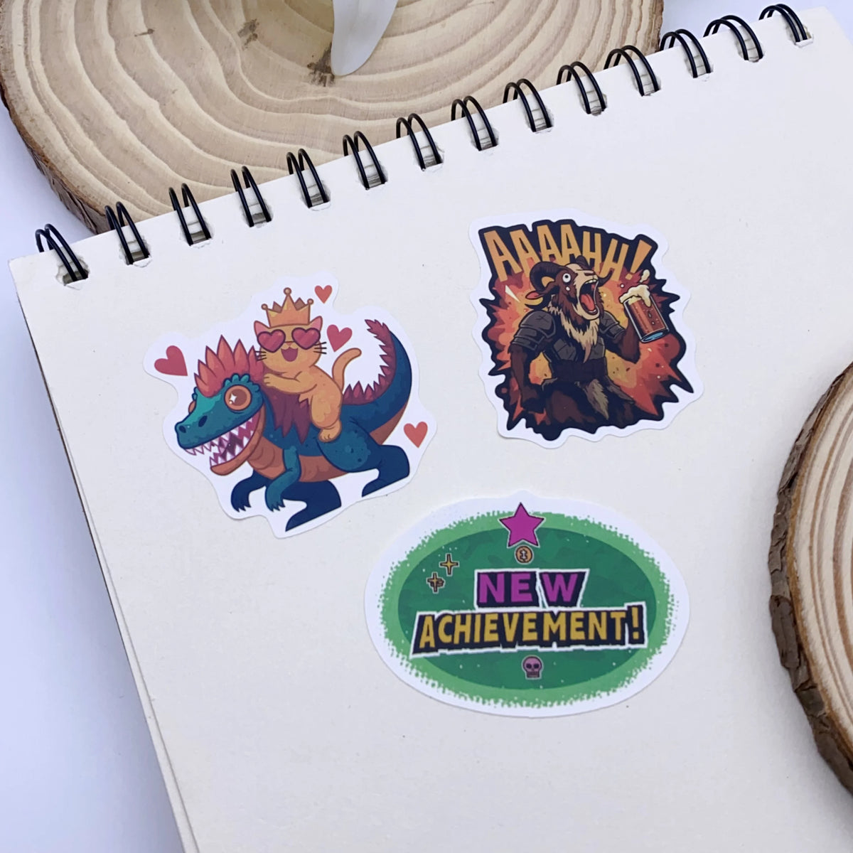 A set of colorful stickers featuring a dinosaur and a pirate-like character on a spiral notebook.