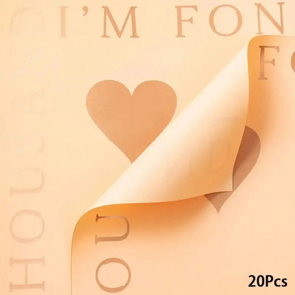 A sheet of peach-colored floral wrapping paper with a heart cutout and text visible on the background.
