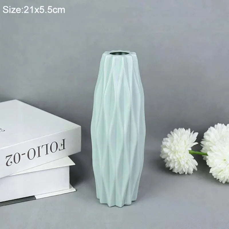 A tall, light mint green decorative plastic vase with vertical ribbed texture.