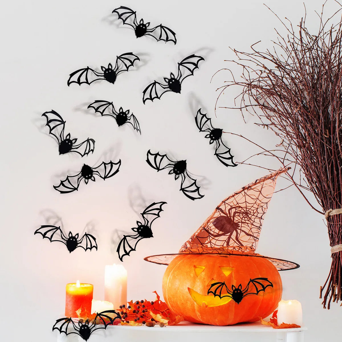 A carved pumpkin sits next to black bat wall decals on a white surface.