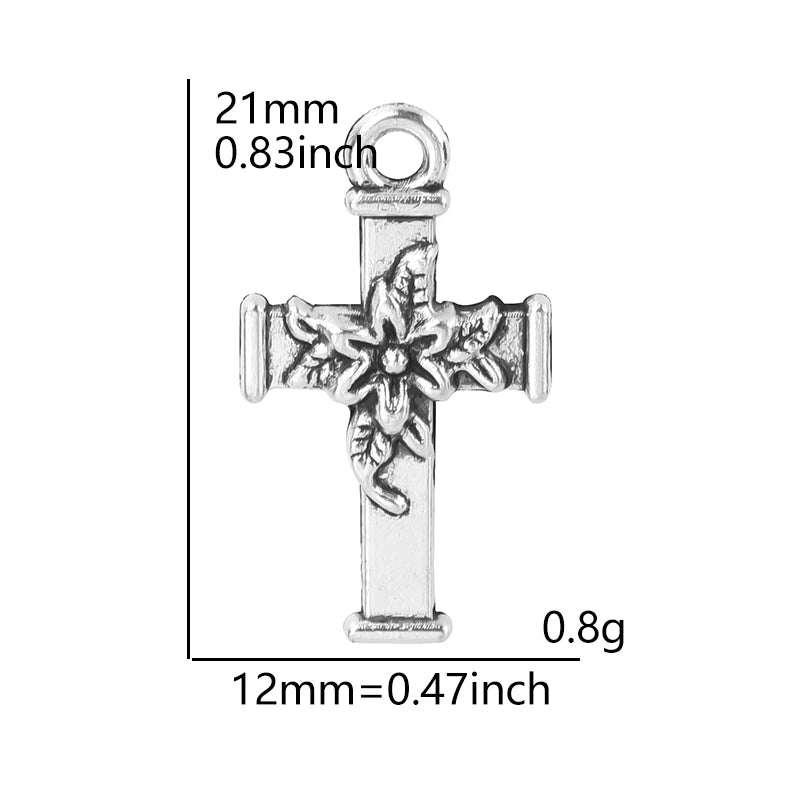 Antique silver cross charm with a detailed floral design and a loop for jewelry making