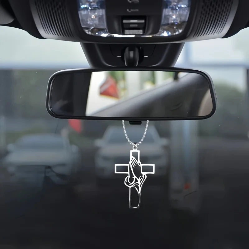 Silver cross pendant depicting open prayer hands hanging from a chain
