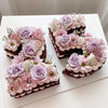 A set of purple and pink floral cake toppers featuring gold butterfly accents