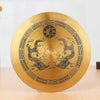 A round, brass Feng Shui Zen table gong featuring intricate designs of dragons and Taiji symbols.