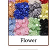 Una variedad colorida de adornos de resina en forma de flor para hacer joyería.