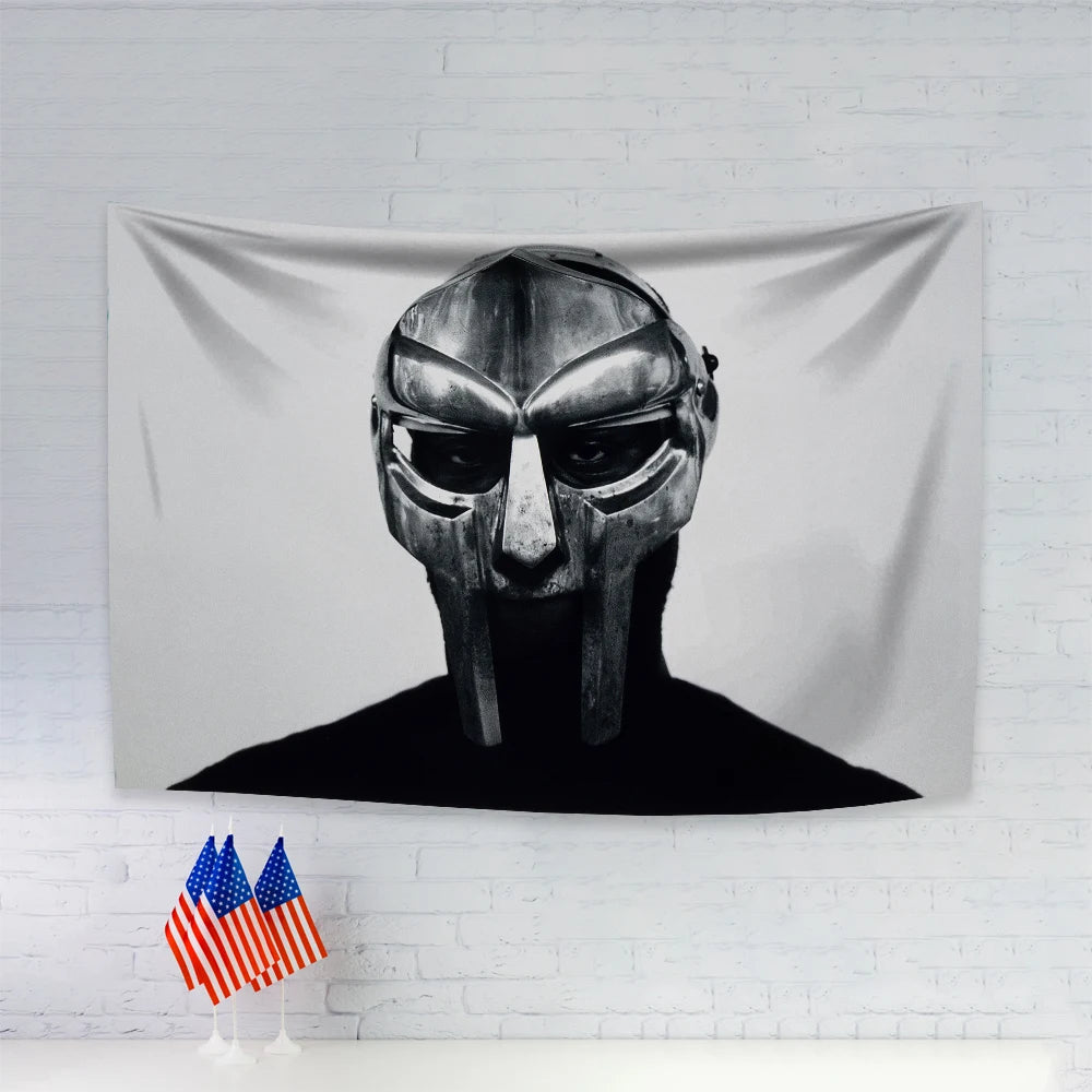 A black and white portrait of a stylized face on a gray fabric tapestry.