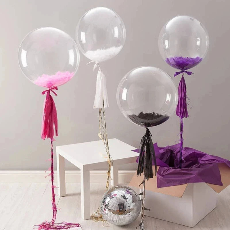 A display of transparent inflatable bobo balloons in various colors, including pink, purple, and black, on a white table.
