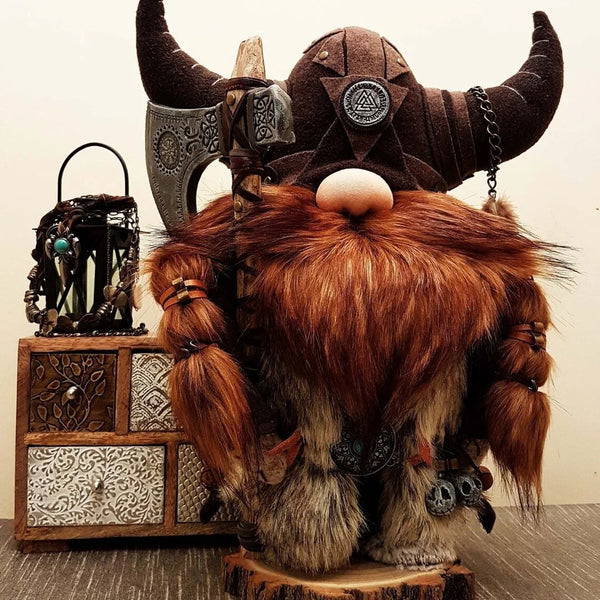 A handmade Viking gnome garden statue featuring a brown leather helmet, a large reddish-brown beard, and fur accents.
